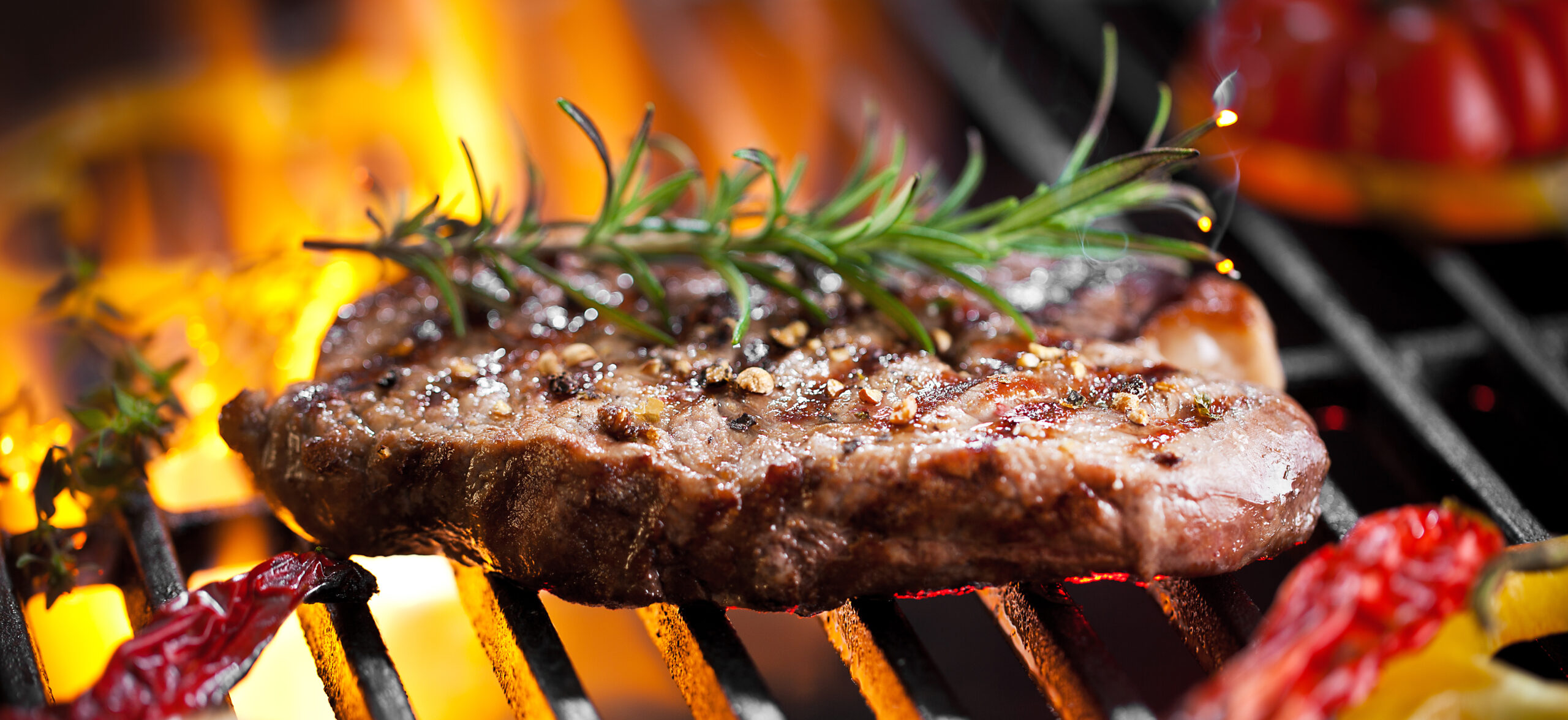 Image of steak on the grill with garnish